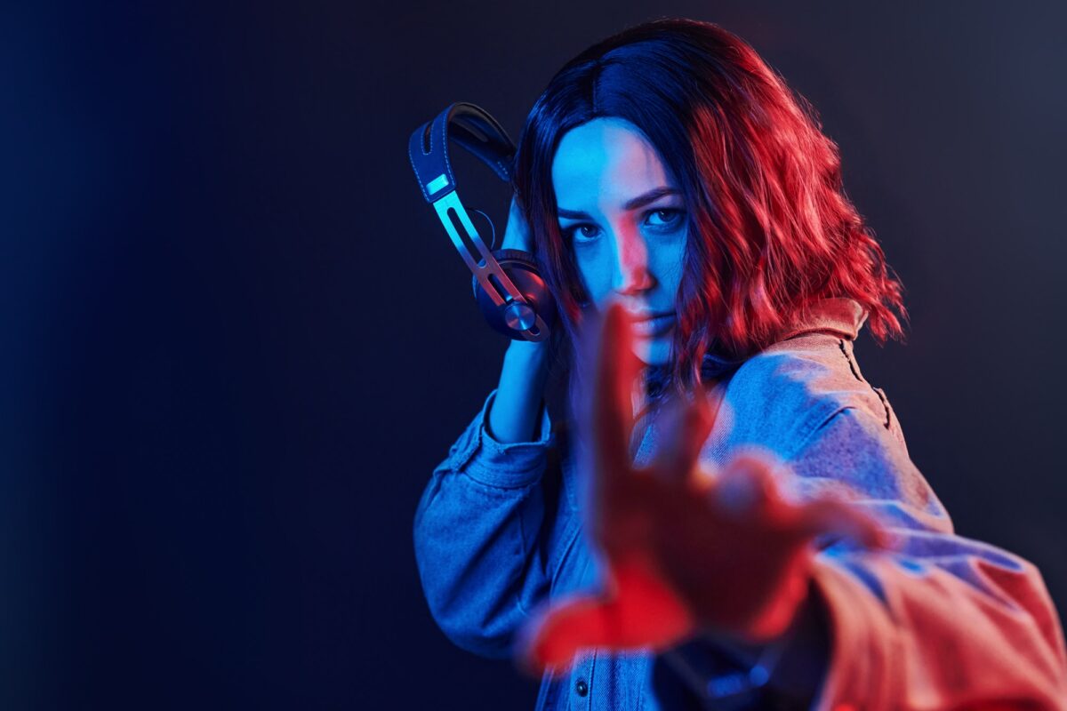 portrait of young girl that listening to music in headphones in red and blue neon in studio.jpg