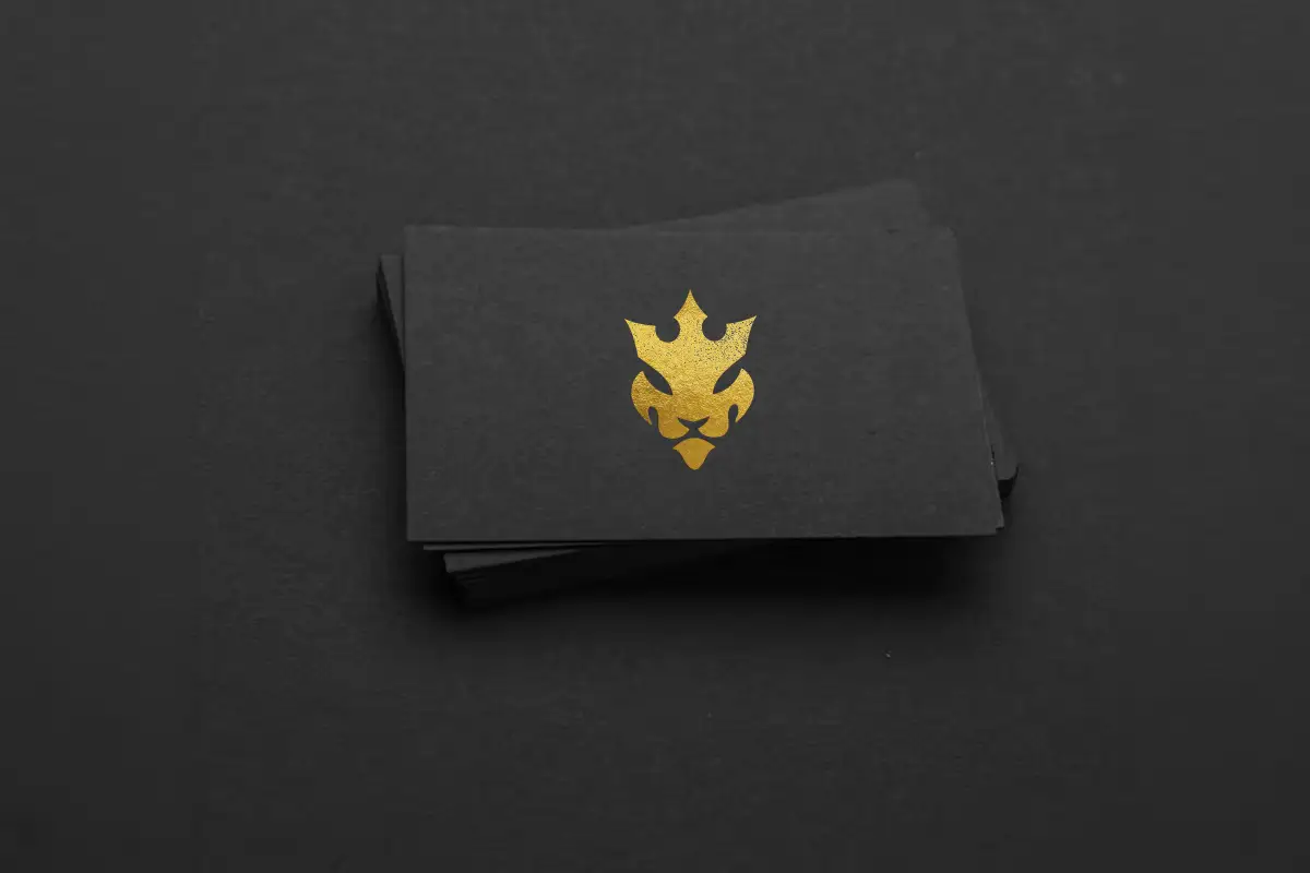 Gold lion emblem printed on a black business card as part of a premium brand identity