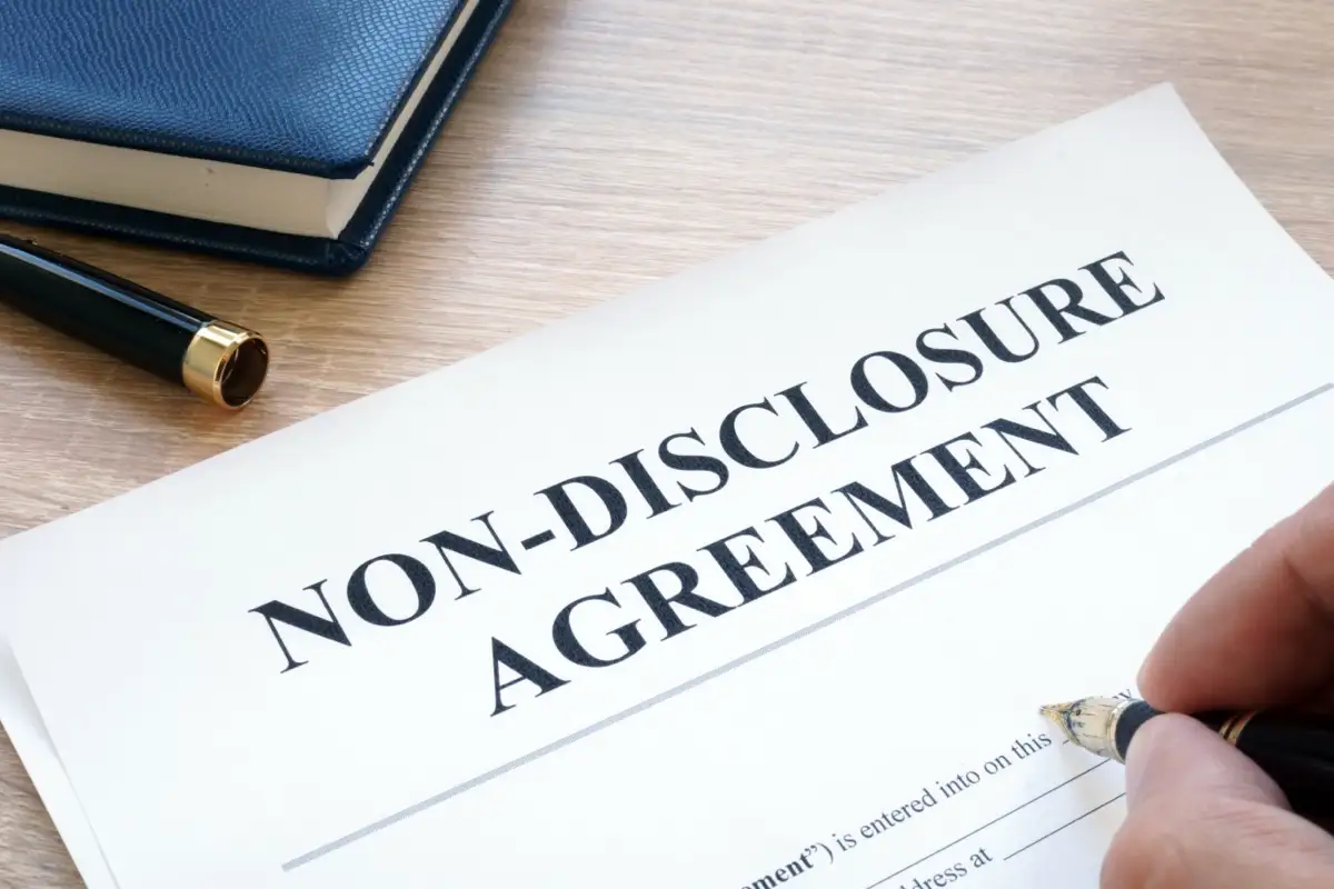 Non-disclosure agreement document being signed, representing confidentiality and protection of sensitive business information